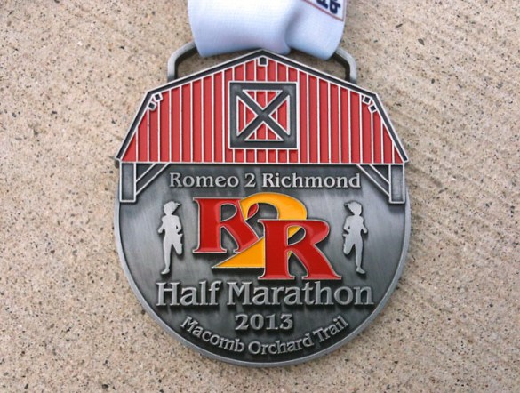The medal features the barn-like covering over M-53 at the start of the race